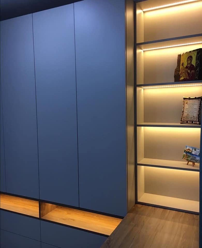 Detaliu al dulapurilor și al vitrinei deschise iluminate. Lucrare Mobi Design în București.